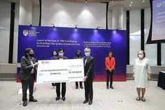 DANA BANTU PELAJAR MEMERLUKAN: Pengarah Urusan Santarli Construction Pte Ltd, Encik Lee Boon Teow (kiri) menyampaikan cek $1 juta kepada Encik Heng (tengah) dan Profesor Ling San bagi Dana Endowmen Profesor Chen Charng Ning. Turut menyaksikan ialah beberapa tamu termasuk balu Profesor Chen (kanan). - Foto MCI