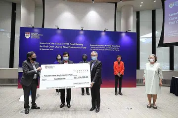 DANA BANTU PELAJAR MEMERLUKAN: Pengarah Urusan Santarli Construction Pte Ltd, Encik Lee Boon Teow (kiri) menyampaikan cek $1 juta kepada Encik Heng (tengah) dan Profesor Ling San bagi Dana Endowmen Profesor Chen Charng Ning. Turut menyaksikan ialah beberapa tamu termasuk balu Profesor Chen (kanan). - Foto MCI