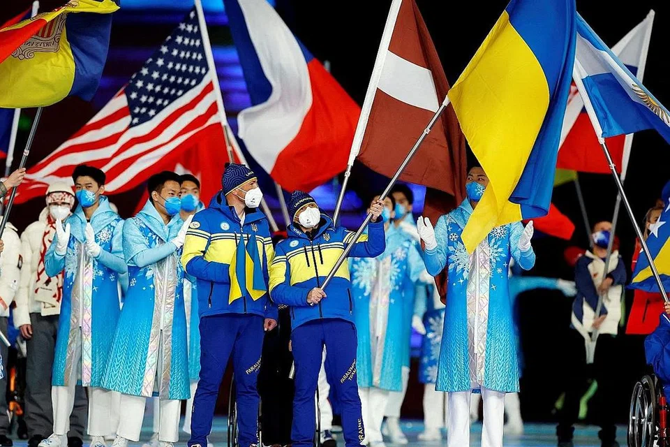 HARAPAN KEAMANAN: Atlet serta relawan mengibarkan bendera negara masing-masing di majlis penutupan Sukan Paralimpik Musim Sejak Beijing kelmarin. - Foto REUTERS