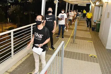PEMINAT BERTUAH: Peminat beratur untuk masuk ke Stadium Tertutup Singapura untuk menonton acara Inside The Matrix One Championship kelmarin, iaitu acara sukan secara langsung dengan kehadiran penonton pertama Singapura di tengah-tengah pandemik Covid-19. - Foto BM oleh DESMOND WEE