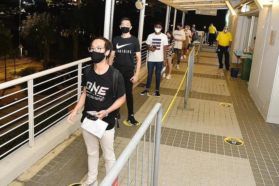PEMINAT BERTUAH: Peminat beratur untuk masuk ke Stadium Tertutup Singapura untuk menonton acara Inside The Matrix One Championship kelmarin, iaitu acara sukan secara langsung dengan kehadiran penonton pertama Singapura di tengah-tengah pandemik Covid-19. - Foto BM oleh DESMOND WEE