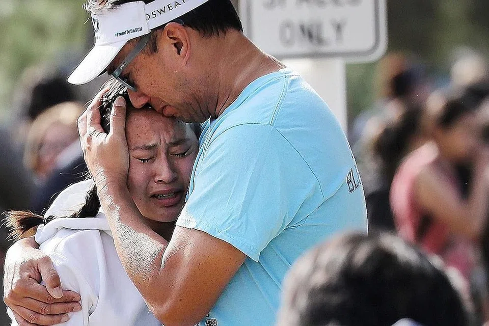 LEGA: Seorang bapa memeluk anak perempuannya yang terselamat selepas insiden tembakan di Sekolah Tinggi Saugus di Santa Clarita, California, kelmarin. - Foto AFP