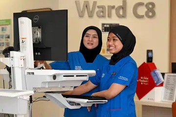 Cik Nur Fitrah Nasuha Hussin (kanan) mengikuti jejak ibunya, Cik Nor Ashikin Sariadi (kiri), dalam kerjaya penjagaan kesihatan. Beliau merupakan Jururawat Staf manakala Cik Nor Ashikin ialah Jururawat Berdaftar Kanan, kededua mereka bertugas di Hospital Besar Ng Teng Fong (NTFGH).