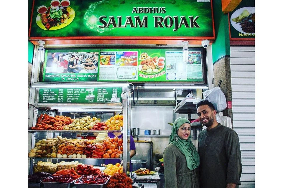 MANFAATKAN SKIM: Ministry of Rojak terjejas akibat Covid-19 tetapi dapat pulih sedikit selepas pasangan Cik Nadira Ahamed Basir dan suaminya, Encik Abdus Salam s/o Akber Ali (gambar atas) mendapatkan bantuan Pusat SME bagi mendapatkan Pakej F&B Booster yang mengurangkan kos perniagaan dan membolehkan kedai makanan itu menyediakan khidmat penghantaran serata Singapura. Gambar ini diambil sebelum wabak Covid-19 melanda negara. - Foto MINISTRY OF ROJAK