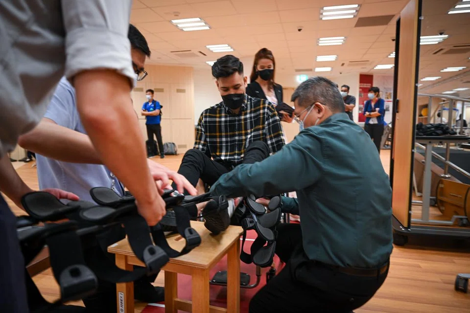 GIGIH BERLATIH: Pakar fisioterapi kelihatan melengkapkan rangka bagi menegakkan kaki sebelum melakukan latihan berjalan.