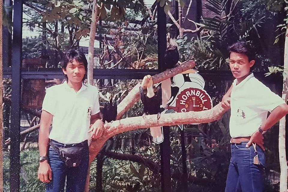 DIDIK PENGUNJUNG: Encik Saad (kanan) di sesi 'Hornbill Chit Chat' pertamanya di mana penjaga burung membawa keluar burung enggang dalam sesi perkongsian bersama tetamu. Gambar diambil pada tahun 1990-an. - Foto ihsan MOHAMAD SAAD YAHYA.