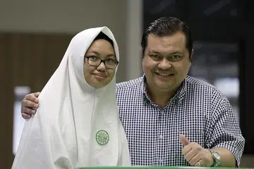 TEKAD BERUSAHA: Pelajar Madrasah Al-Arabiah, Nur Dayyinah Aqilah dan bapanya, Mohammad Rizal Ismail, seorang kakitangan awam, mahu menunjukkan bahawa pelajar madrasah juga mampu meraih kecemerlangan dan menjadi saintis. - Foto BH oleh AZMI ATHNI