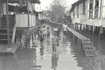 SUDAH BIASA DENGAN AIR: Kanak-kanak di Kampung Sungei Mandai Kechil, sudah terbiasa dengan air laut yang pasang dan banjir dan tidak kekok bermain dan berjalan walaupun dalam suasana perayaan seperti majlis keramaian dan Hari Raya. - Foto fail. 