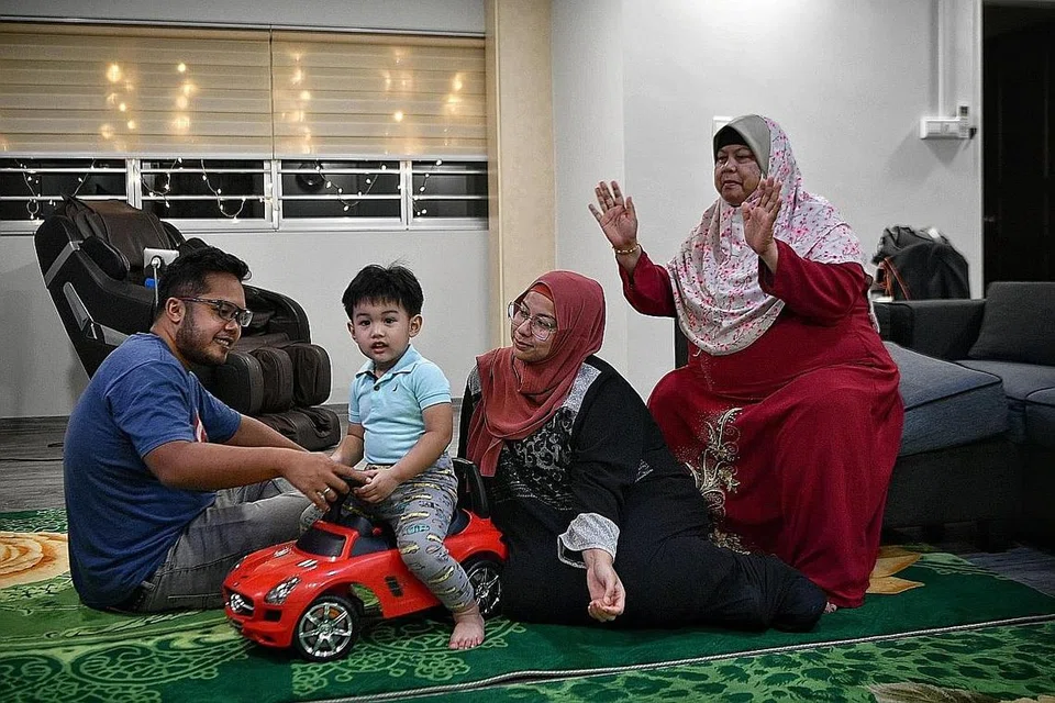 TERPAKSA MENUNGGU: Dengan pembantu rumahnya tersangkut akibat undang-undang baru Kementerian Tenaga Manusia (MOM), Cik Raba'atuladawiah (berbaju hitam) berkata beliau serta suaminya, Encik Zaki, terpaksa membuat rancangan lain untuk ibunya, Cik Saniah Abdullah (kanan), dan anaknya, Adam Zaki, buat sementara ini. - Foto BM oleh ARIFFIN JAMAR