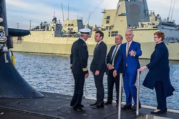 PERJANJIAN DIMUNGKIRI: Gambar yang dirakamkan pada 2 Mei 2018 menunjukkan Presiden Perancis, Encik Emmanuel Macron (dua dari kiri) dan Perdana Menteri Australia ketika itu, Encik Malcolm Turnbull (dua dari kanan) berdiri di pelantar kapal selam kelas Collins, HMAS Waller, yang dikendalikan Angkatan Tentera Laut Diraja Australia di Garden Island, Sydney. Australia membatalkan perjanjian bernilai AUD$90 bilion ($88.16 bilion) dengan Perancis bagi membina kapal selam, dan menggantikannya dengan kapal selam berkuasa nuklear menggunakan teknologi Amerika Syarikat dan British. - Foto AFP