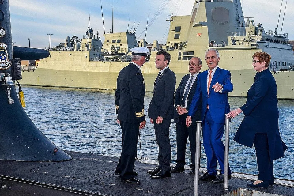 PERJANJIAN DIMUNGKIRI: Gambar yang dirakamkan pada 2 Mei 2018 menunjukkan Presiden Perancis, Encik Emmanuel Macron (dua dari kiri) dan Perdana Menteri Australia ketika itu, Encik Malcolm Turnbull (dua dari kanan) berdiri di pelantar kapal selam kelas Collins, HMAS Waller, yang dikendalikan Angkatan Tentera Laut Diraja Australia di Garden Island, Sydney. Australia membatalkan perjanjian bernilai AUD$90 bilion ($88.16 bilion) dengan Perancis bagi membina kapal selam, dan menggantikannya dengan kapal selam berkuasa nuklear menggunakan teknologi Amerika Syarikat dan British. - Foto AFP