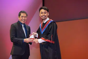KEJAYAAN CEMERLANG: Encik Mohamad Hilman Mohamad Hatta (kanan) menerima Pingat Emas Ngee Ann Kongsi bagi Anugerah Graduan Institut Pendidikan Teknikal (ITE) Terbaik bagi sumbangan dan prestasi kursus cemerlang daripada tetamu kehormat, Menteri Kedua (Pendidikan merangkap Ehwal Luar), Dr Mohamad Maliki Osman, pada Julai 2022. - Foto-foto ihsan MOHAMAD HILMAN MOHAMAD HATTA