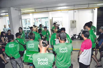 MAHU SUARAKAN KEPRIHATINAN: Sekitar 50 pengguna alat mobiliti peribadi (PMD) yang juga penghantar makanan, berkumpul semasa sesi bertemu penduduk di Ang Mo Kio malam kelmarin untuk menyuarakan keprihatinan berkenaan larangan penggunaan PMD di laluan pejalan kaki. - Foto BH oleh DESMOND WEE
