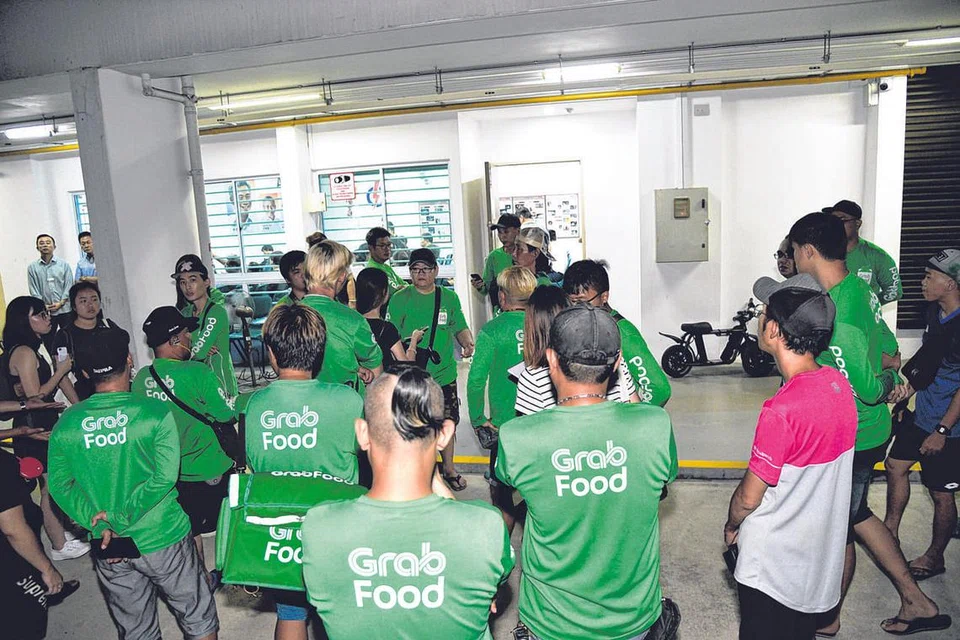 MAHU SUARAKAN KEPRIHATINAN: Sekitar 50 pengguna alat mobiliti peribadi (PMD) yang juga penghantar makanan, berkumpul semasa sesi bertemu penduduk di Ang Mo Kio malam kelmarin untuk menyuarakan keprihatinan berkenaan larangan penggunaan PMD di laluan pejalan kaki. - Foto BH oleh DESMOND WEE