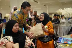 Menteri di Pejabat Perdana Menteri merangkap Menteri Kedua (Pendidikan dan Ehwal Luar), Dr Mohamad Maliki Osman (tengah) bersama penerima bantuan Tabung Amal Aidilfitri (TAA), Cik Nuralysya Abdul Hamid (kiri) yang menghidap sindrom ‘femoral facial’ dan ibunya, Cik Siti Mazurah (kanan).