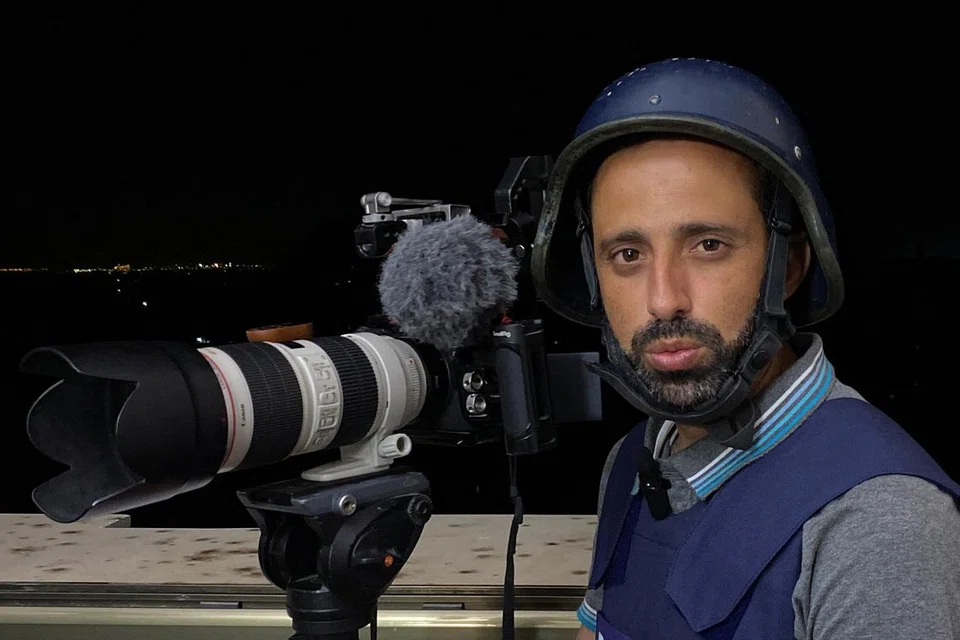 BERANIKAN DIRI: Wartawan agensi berita Reuters, Encik Mohammed Salem, bergambar bersama kameranya ketika menjalankan tugas membuat laporan  perang Israel-Palestin daripada sebuah bangunan di bandar Gaza.