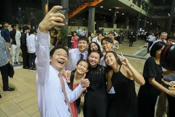 Timbalan Perdana Menteri, Encik Lawrence Wong (depan), bergambar bersama atlet-pelajar Sekolah Sukan Singapura ketika menghadiri sambutan ulang tahun ke-20 dan malam anugerah sekolah itu di kampusnya di Woodlands pada 26 April.