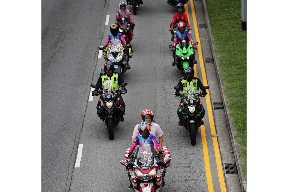 SERTAI USAHA AMAL BIKERS: Encik Amrin membonceng motosikal (paling depan) sewaktu acara pengagihan makanan dan bahan keperluan kepada golongan kurang bernasib baik anjuran MAEC dan kumpulan bikers. - Foto BH oleh KELVIN CHNG