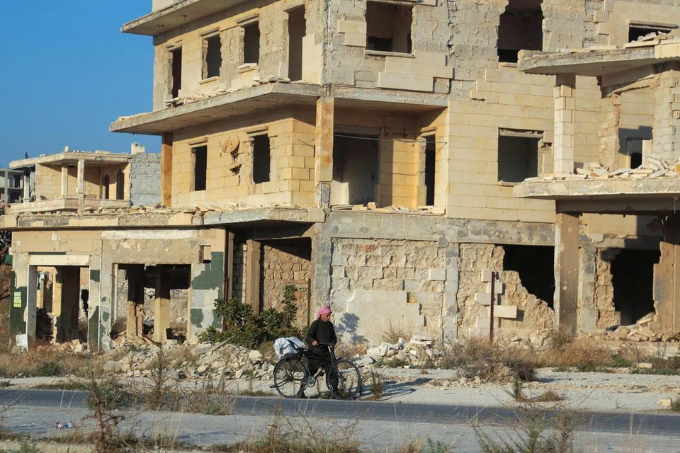 Seorang lelaki melintasi runtuhan bangunan yang rosak di bandar Tel Rifaat, Syria, pada 2 Disember. Kawasan itu mengalami kemusnahan besar selepas bertahun-tahun pertempuran sengit melanda bandar tersebut.