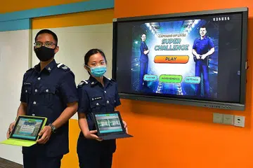 MANFAATKAN TEKNOLOGI DALAM LATIHAN: SGT2 Muhammad Jaffariz Siddiq Ahmad Azeri (kiri) dan SGT2 Neo Fang Ning menunjukkan aplikasi MITA. - Foto BH oleh NG SOR LUAN