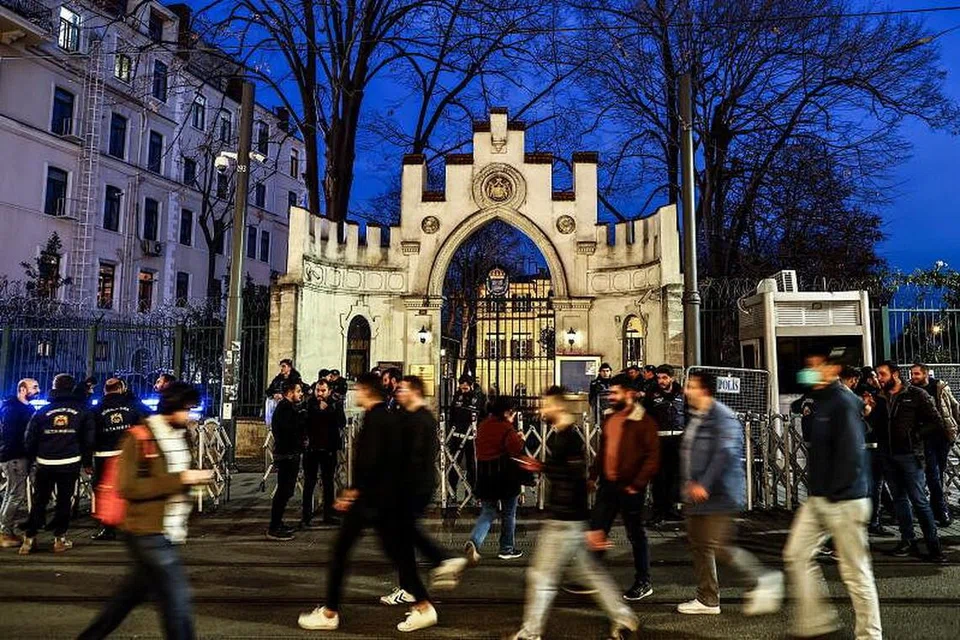 Orang awam berjalan lalu pegawai polis rusuhan Turkey yang sedang mengawal semasa satu bantahan di luar Konsult Jeneral Sweden di Istanbul pada Sabtu (22 Jan). Para penunjuk perasaan berhimpun selepas ahli politik sayap kanan Sweden-Denmark, Rasmus Paludan dibenarkan membakar senaskhah Quran di depan kedutaan Turkey di Stockholm pada 21 Januari. 