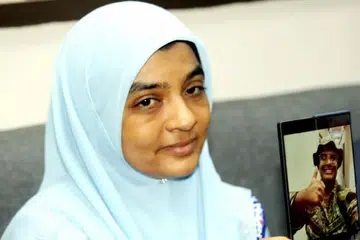 Cik Ummu Haiman Bee Daulatgun, 45 tahun, menunjukkan gambar anaknya, Allahyarham Syamsul Haris Shamsudin, yang meninggal dunia semasa menjalani latihan tentera di Johor.
