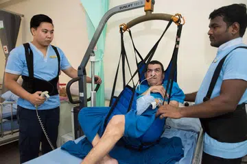 LEBIH SELAMAT: Kakitangan Darul Syifaa bertali pinggang khas bagi melindungi tulang belakang mereka semasa menggunakan alat terkini untuk mengalihkan pesakit yang sukar bergerak di rumah rawatan itu.- Foto BH oleh SYAMIL SAPARI