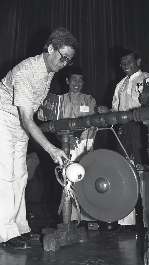 Mantan Menteri Negara (Budaya), mendiang, Encik Fong Sip Chee (kiri) memukul gong sempena pelancaran Bulan Bahasa pada 1982 dilihat oleh mantan timbalan pengerusi dan juga sasterawan Allahyarham Suratman Markasan (tengah).