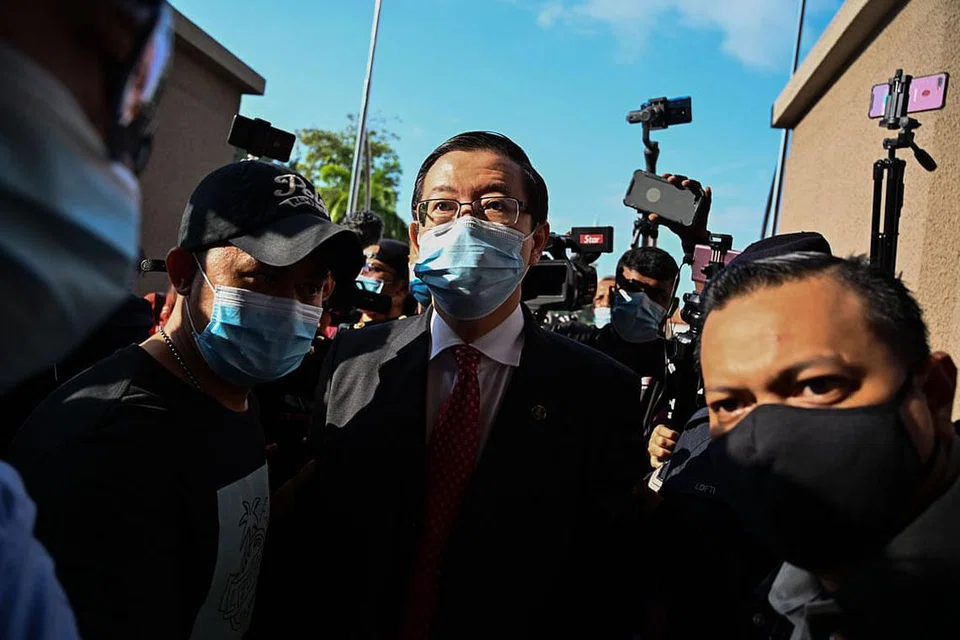 HADAPI PENDAKWAAN: Lim Guan Eng, yang diiringi pegawai SPRM, dikerumuni wartawan semasa tiba di mahkamah semalam. Dia menghadapi dua tuduhan rasuah membabitkan projek terowong dasar laut di Pulau Pinang. - Foto AFP