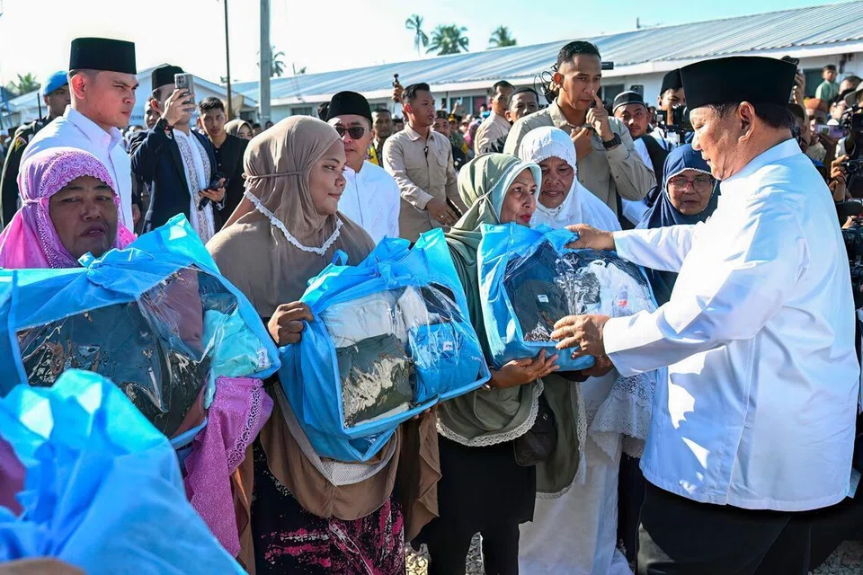 Gambar edaran yang dirakam dan dikeluarkan pada 21 Mac 2026 oleh Istana Presiden menunjukkan Presiden Indonesia, Prabowo Subianto (kanan), mengagihkan bantuan kepada mangsa banjir selepas menunaikan solat Aidilfitri di Masjid Darussalam, Aceh Tamiang, Aceh