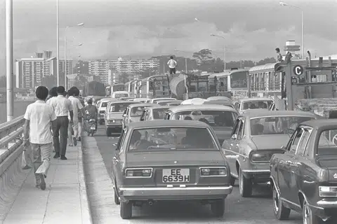 1976: Kesibukan cuti Krismas menyebabkan kesesakan lalu lintas di sepanjang Koswe. Ramai orang meninggalkan bas dan teksi dan berjalan menuju ke imigresen.