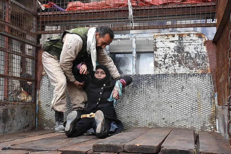 CARI PERLINDUNGAN: Seorang wanita Syria yang cedera di kawasan kejiranan al-Sukkari di Aleppo dibantu menaiki trak semasa beliau sedang melarikan diri dalam operasi ketenteraan pemerintah Syria semalam. Satu gencatan senjata kini dilaksanakan bagi membolehkan penduduk Aleppo dipindah keluar dari bandar itu. - Foto AFP