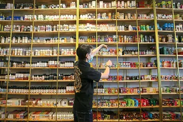 BANYAK PILIHAN: Seorang pekerja menyusun perisa berbeza di kedai ‘vape’ di Cheras.