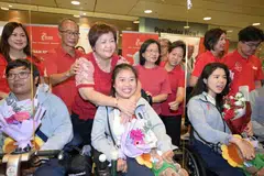 Pemenang pingat perak boccia di Sukan Paralimpik 2024, Jeralyn Tan (tengah), bersama ibu, Goh Leng Buay, 60 tahun, dan bapa, Rayven Tan, 62 tahun, di Lapangan Terbang Changi pada 10 September. Atlet memanah para, Nur Syahidah Alim (kiri) dan perenang para, Yip Pin Xiu (kanan).