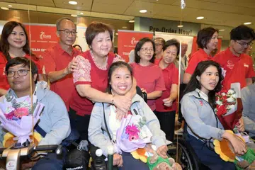Pemenang pingat perak boccia di Sukan Paralimpik 2024, Jeralyn Tan (tengah), bersama ibu, Goh Leng Buay, 60 tahun, dan bapa, Rayven Tan, 62 tahun, di Lapangan Terbang Changi pada 10 September. Atlet memanah para, Nur Syahidah Alim (kiri) dan perenang para, Yip Pin Xiu (kanan).