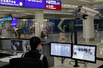 PENULARAN PNEUMONIA WUHAN: Seorang pegawai memantau penumpang yang tiba di Lapangan Terbang Antarabangsa Hong Kong menyusuli penularan pneumonia di Wuhan.