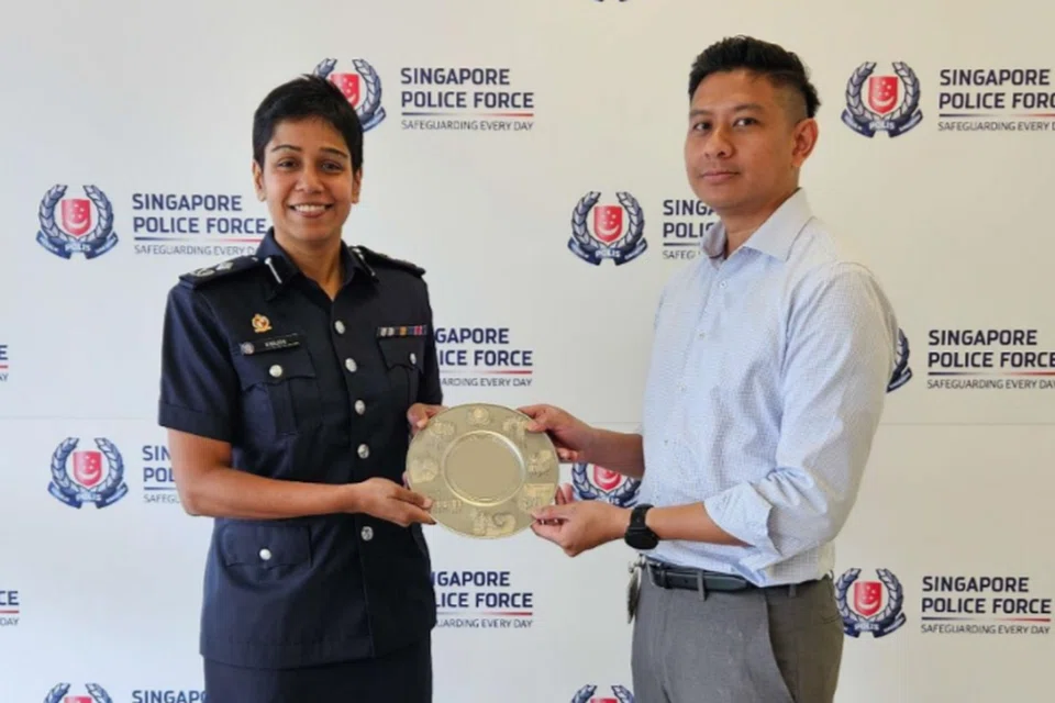 Encik Muhammad Helmi Ali (kanan) menerima pingat Anugerah Semangat Kemasyarakatan Awam daripada Penolong Pesuruhjaya Kanan, Cik M Malathi (kiri) pada 30 Mei.