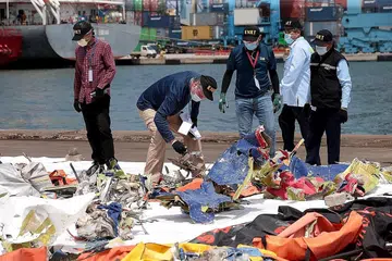 TELITI SERPIHAN: Para penyiasat memeriksa serpihan pesawat Sriwijaya Air SJ 182, yang ditemui dari lokasi nahas di perairan luar Jakarta, di pelabuhan Tanjung Priok di Jakarta, Indonesia. - Foto EPA-EFE