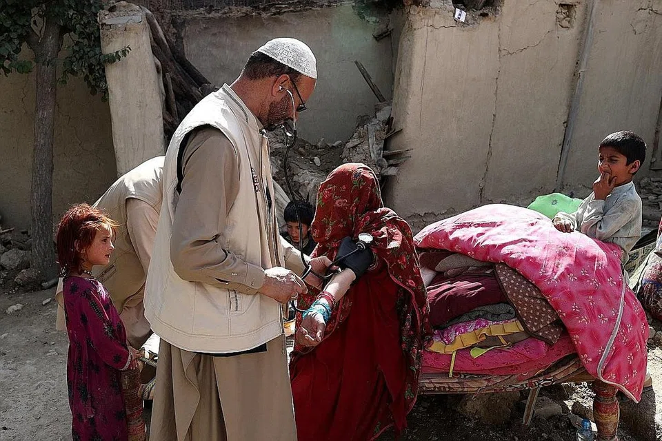 RAWATAN DOKTOR: Seorang wanita Afghanistan sedang mendapat rawatan doktor di Gayan yang terjejas ekoran gempa bumi di Afghanistan. - Foto REUTERS