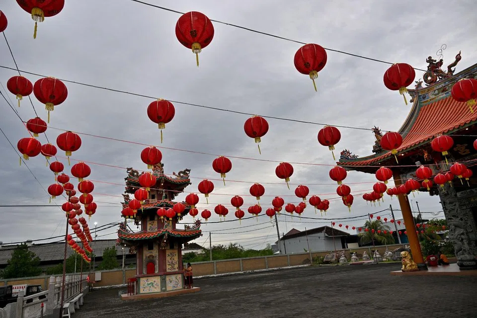 Seorang wanita memohon di bawah ‘ampion’ atau lampu tanglung merah yang dipasang sempena sambutan Tahun Baru Cina di sebuah kuil di Denpasar, pulau peranginan Bali, pada 21 Januari.