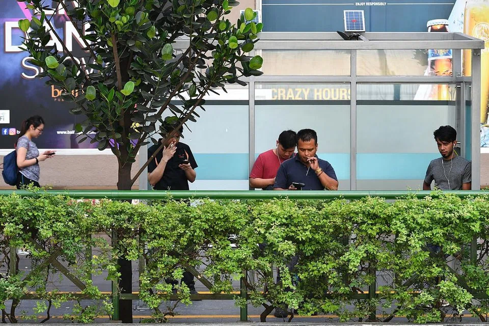 ROKOK DI KAWASAN TETAP: Perokok dirakam merokok di salah satu kawasan merokok ditetapkan berdekatan Orchard Towers. Bermula semalam, perokok tidak dibenarkan merokok secara sebarangan di Orchard Road. - Foto BH oleh LIM YAOHUI