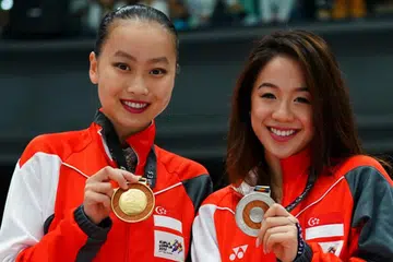 EMAS, PERAK UNTUK SINGAPURA: Yu Shuran (kiri dalam gambar atas) dan Chloe Ing membuktikan kehandalan Singapura dalam acara meluncur ais yang julung-julung kali dipertandingkan di peringkat Sukan SEA. - Foto SPORTSG