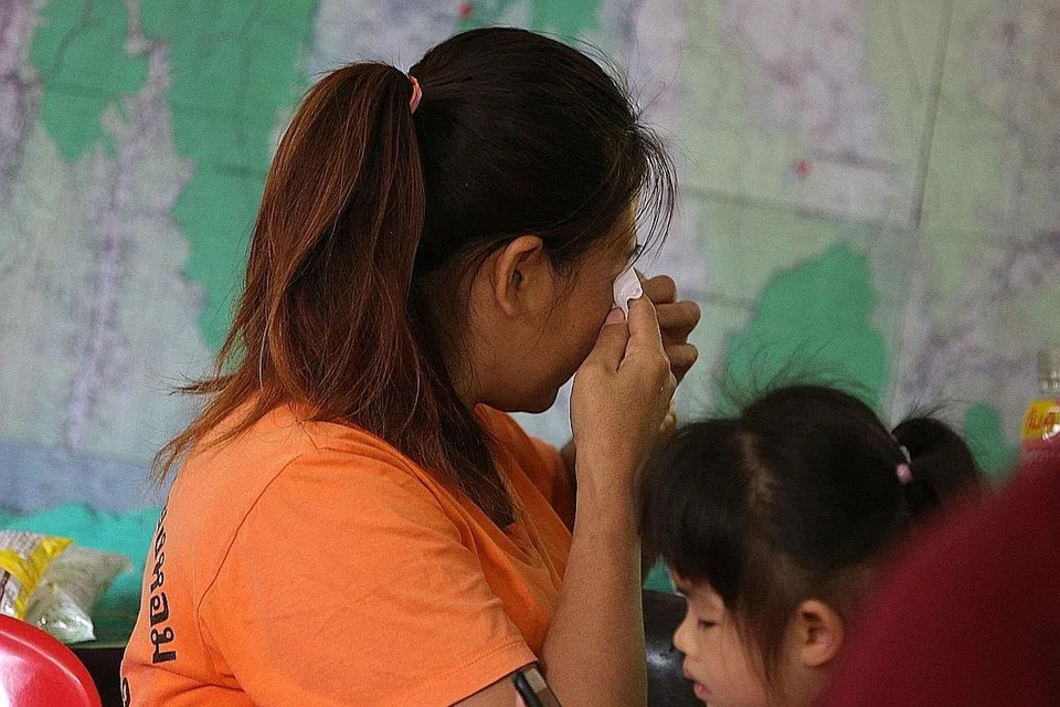 DILANDA HIBA: Anggota keluarga mangsa sedih mendengar pengumuman tentang kematian penyelam Saman Kunan menerusi sidang media semalam. - Foto REUTERS