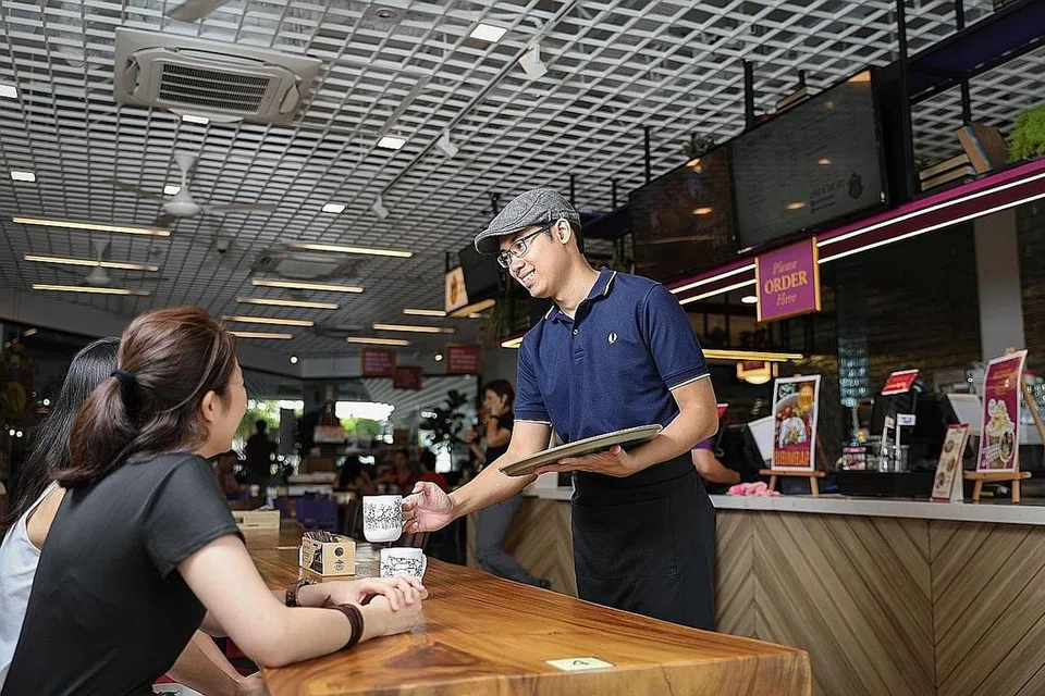 MEMPERKASA DIRI DALAM INDUSTRI F&B: Encik Muhammad Khairul Asmi (kanan) berkata beliau kini lebih yakin menjalankan tugas khusus dalam industri makanan dan minuman (F&B) dengan latihan yang dijalani di Kafe Professor Brawn, yang menyediakan latihan bagi golongan berkeperluan khas. Kafe tersebut membuka pintunya kepada orang awam, sekali gus memainkan peranan sebagai 'jambatan' penghubung antara mereka yang berkeperluan khas dan orang biasa. - Foto BH oleh KEVIN LIM