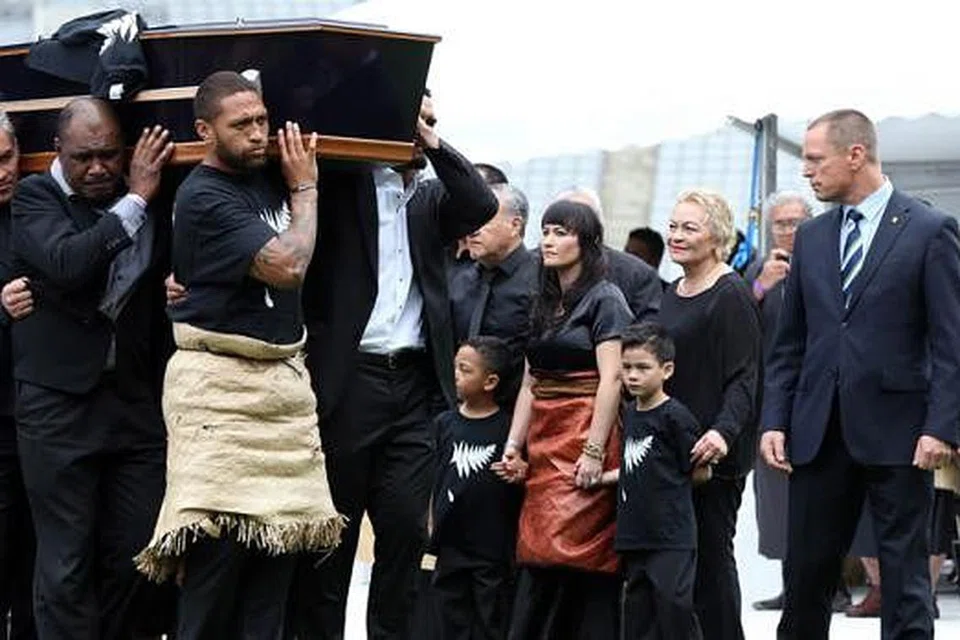 PENGHORMATAN TERAKHIR: Balu Lomo, Nadene (kain merah), dan dua anak mereka, Brayley dan Dhyreille (dipimpin Nadene), menyaksikan upacara pengebumian semalam.- Foto AFP