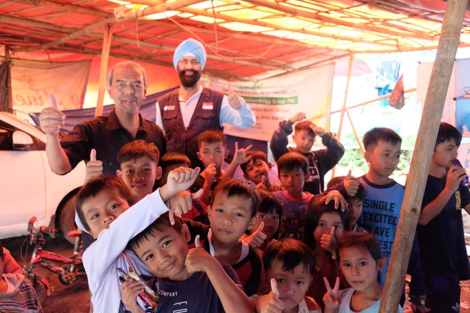 BERI SOKONGAN: Pengerusi RLAF, Encik Abdul Razak Hassan Maricar (kiri) dan Pengerusi Mercy Relief, Encik Satwant Singh bersama kanak-kanak di Kampung Talaga.