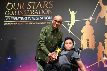 Presiden Tharman Shanmugaratnam menyampaikan Anugerah Ketabahan kepada Muhammad Ridhwan Mohammad Fadli pada majlis Anugerah AWWA-CIS 2025 di Safra Choa Chu Kang. 