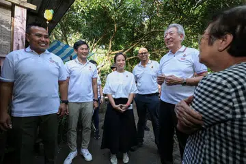 Anggota Parlimen GRC Pasir Ris-Punggol, Encik Sharael Taha (kiri); Menteri Negara Kanan (Pejabat Perdana Menteri), Encik Desmond Tan (dua dari kiri); Ketua Hal Ehwal Korporat Sembcorp untuk Singapura dan Asia Tenggara, Cik Valerie Lee (tengah); Menteri Negara Kanan (Kesihatan merangkap Penerangan dan Pembangunan Digital), Dr Janil Puthucheary (empat dari kiri); dan Menteri Kanan, Encik Teo Chee Hean (dua dari kanan); beramah mesra dengan penduduk Pulau Ubin semasa membuat lawatan ke pulau itu pada 11 April.