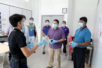 BERAMAH MESRA: Encik Amrin (tengah) beramah mesra dengan kakitangan barisan hadapan di dormitori Tuas South. Kanan sekali ialah Superintenden Amir. - Foto MHA