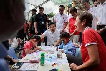 Perdana Menteri Lawrence Wong (duduk) bersama Anggota Parlimen (AP) GRC Jalan Besar - Cik Josephine Teo (duduk), Encik Heng Chee How (tiada dalam gambar), Cik Denise Phua dan Dr Wan Rizal Wan Zakariah (berdiri dua dan tiga dari kanan) - serta AP Potong Pasir, Encik Sitoh Yih Pin (berdiri kanan), menemui penduduk pada acara ‘SG60 Bina dengan Kasih Sayang’ di Kreta Ayer Square pada 4 Januari.
